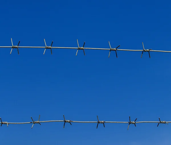 Nuevo alambre de púas contra el cielo azul —  Fotos de Stock