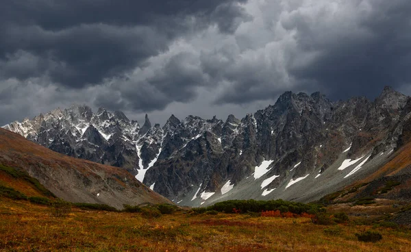 低嵐の雲が雪の山の上に触れる 大きな岩や氷河と異常曇り素晴らしい風景 — ストック写真
