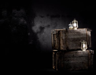 Bodrumdaki ahşap kutuların üzerindeki eski lamba. Seçici odak