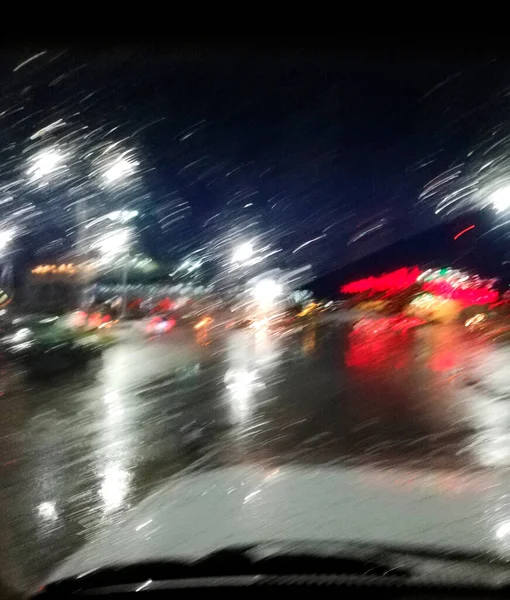 Blurred view from the car window in the evening in the rain