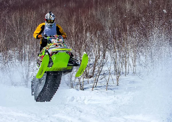 Moto de nieve en salto alto por encima de la pista. Enfoque selectivo — Foto de Stock