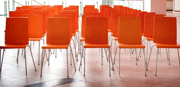 Sala de conferencias con sillas rojas, suelo de hormigón y ventanas. Enfoque selectivo —  Fotos de Stock
