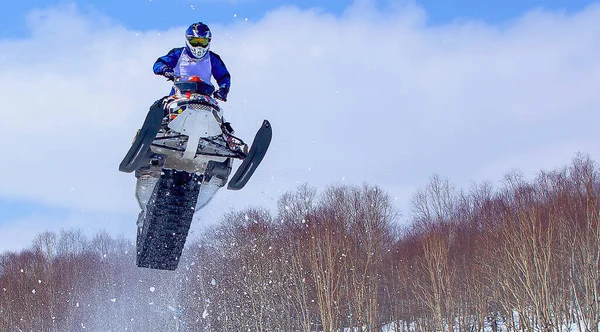 Moto de nieve en salto alto por encima de la pista. Enfoque selectivo — Foto de Stock