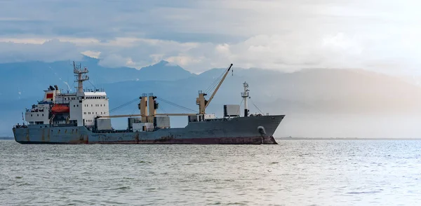 Large cargo container ship sailing against the volcano — Stock Photo, Image