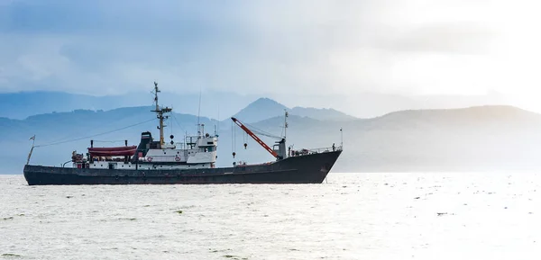 Grand bateau de pêche sur fond de collines et de volcans — Photo