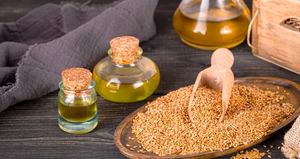 Оливковое масло и семена кунжута на деревянной поверхности — стоковое фото