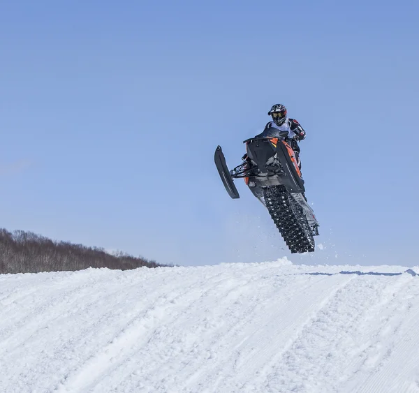 Moto de nieve en la ruta en un salto en el aire —  Fotos de Stock