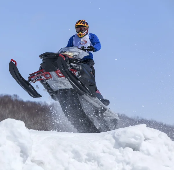 Moto de nieve en la ruta en un salto en el aire —  Fotos de Stock