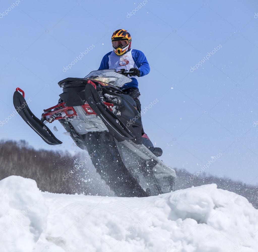 Snowmobile on the route in a jump in air