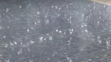 Yağmur damlaları su birikintisine düşer. Fırtına sırasında yağmur yağıyor.