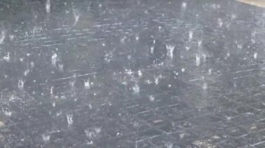 Yağmur damlaları su birikintisine düşer. Fırtına sırasında yağmur yağıyor.