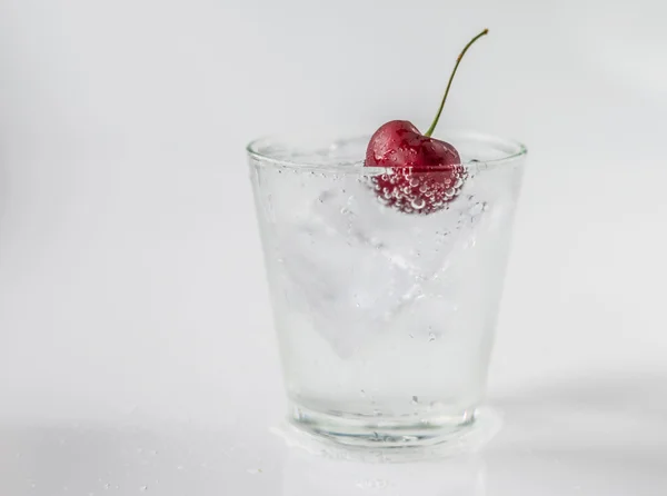 Cherry in glass of soda and ice — Stock Photo, Image