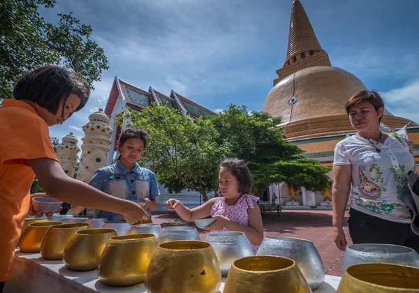 People make merit by donating coin into monk bowl — Stock Photo, Image