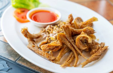 Kızarmış küçük balıklar ya da sarımsaklı Sillago balıkları. Kızarmış Sillago beyaz tabakta restoranda masada. Tayland yemek görüntüsünü kapat. Taylandca Sillago veya Pla Hed Cone.