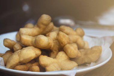 Patongko ya da kızarmış hamur çubukları, geleneksel Çin ve Tayland kahvaltısı, Patongko 'yu kapatın ya da kızarmış hamur çubuklarını beyaz tabağa koyun..