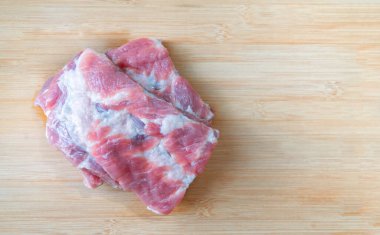 Taze ve temizlenmiş domuz pirzolası, büyük parçalar, küçük parçalara kesilmiş. Bambu doğrama tahtasına yerleştirilmiş, üst görünüm resmi metin için alan, doğal ışık.