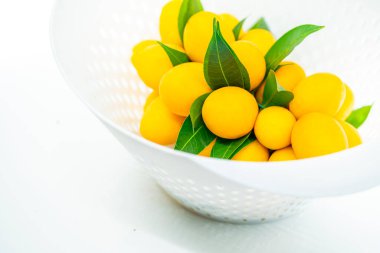 Meyveyi sepete koy, güzel Marian Erik demeti veya modern plastik beyaz sepetle erik mango demeti, tropikal Tayland meyvesi, tatlı ve ekşi Asya meyvesi.