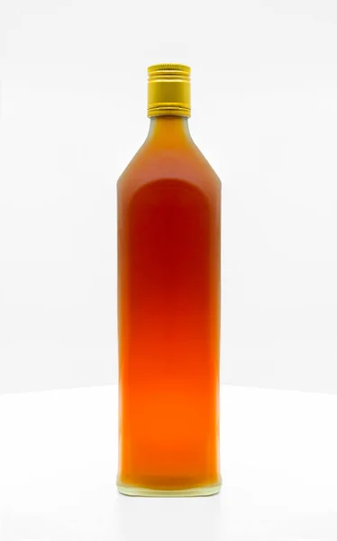 白いテーブルの上に有機蜂蜜酢の美しいマットガラス瓶 ブランドラベルのための空白のスペースとフロント側 金色のキャップ付きの長い形状のマットガラスボトル — ストック写真