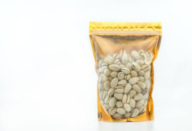 Pencere çantasına yerleştirilmiş fındıklı plastik paketler, üzerinde fermuar kilidi, altın rengi ambalajlar. Tasarım etiketi için boş alanı olan ön görünüm. Resim beyaz arkaplanda.