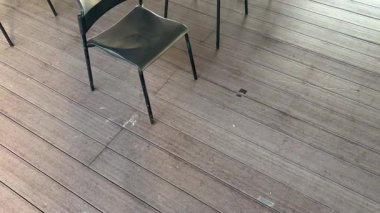 Filmde ahşap bir zeminde siyah sandalyelerin sıralarını yakalar, kamera aşağıdan yukarıya, çerçevenin ortasına hareket eder. Olay yeri, organizasyon duygusunu taşır, etkinlik planlaması için mükemmeldir..