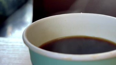 Sıcak kahveyle dolu bir bardağın hala çekimleri ve gerçek zamanlı görüntüleri sıcaklığını vurgulayan yükselen buharı yakalıyor..