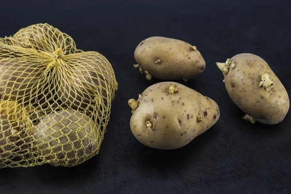 Colorful, bright potatoes, beautifully put on a dark background — Stock Photo, Image