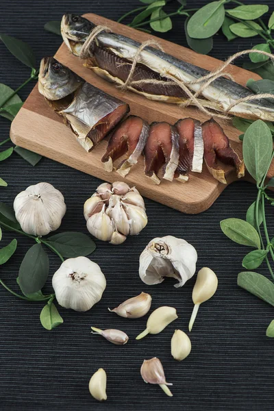 Zusammensetzung aus rotem Fisch, Schneidebrettern, Knoblauch, Seil, braunem Brot, dunklen Handtüchern auf dunklem Hintergrund ausgebreitet — Stockfoto