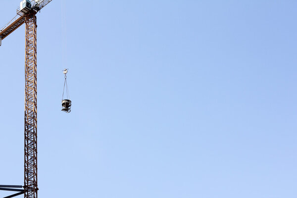 Lifting cargo crane while working on a clear day