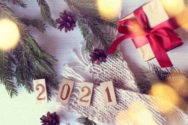 Tablet 2021 masada, köknar dalları ve kozalaklı bir eşarp, bir hediye ve çelenk ışıkları ile. Şenlikli yeni yıl