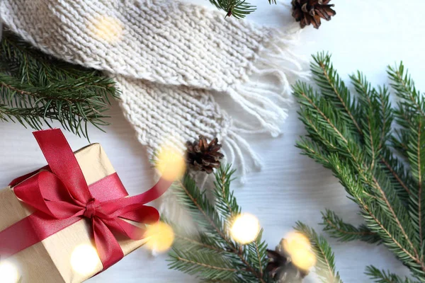 モミの枝やガーランドライトで休日の贈り物やニットスカーフ クリスマスのための暖かい驚き — ストック写真
