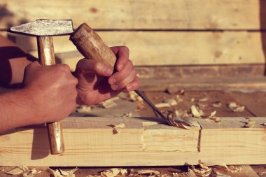 Katılımcının elindeki geridönüşüm araçları iş parçasının / el yapımı ustasının arka planına karşıdır