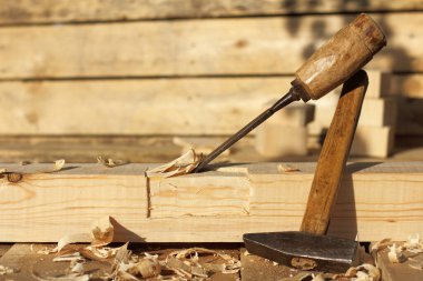 Eski çekiç ve keski ahşap kamaranın yanında mobilya yapıyor.