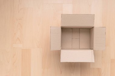 Ahşap arka planda boş dikdörtgen karton kutu. Çevrimiçi nesne arkaplanı alınıyor. Paket nesnesi gönderiliyor.