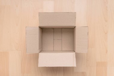 Ahşap arka planda boş dikdörtgen karton kutu. Çevrimiçi nesne arkaplanı alınıyor. Paket nesnesi gönderiliyor.