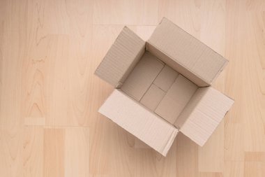Ahşap arka planda boş dikdörtgen karton kutu. Çevrimiçi nesne arkaplanı alınıyor. Paket nesnesi gönderiliyor.