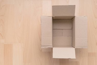 Ahşap arka planda boş dikdörtgen karton kutu. Çevrimiçi nesne arkaplanı alınıyor. Paket nesnesi gönderiliyor.