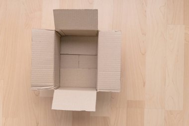 Ahşap arka planda boş dikdörtgen karton kutu. Çevrimiçi nesne arkaplanı alınıyor. Paket nesnesi gönderiliyor.