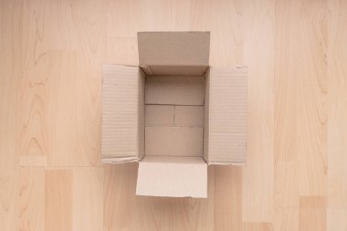 Ahşap arka planda boş dikdörtgen karton kutu. Çevrimiçi nesne arkaplanı alınıyor. Paket nesnesi gönderiliyor.