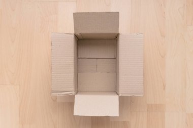 Ahşap arka planda boş dikdörtgen karton kutu. Çevrimiçi nesne arkaplanı alınıyor. Paket nesnesi gönderiliyor.