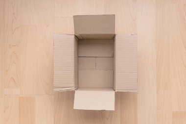 Ahşap arka planda boş dikdörtgen karton kutu. Çevrimiçi nesne arkaplanı alınıyor. Paket nesnesi gönderiliyor.