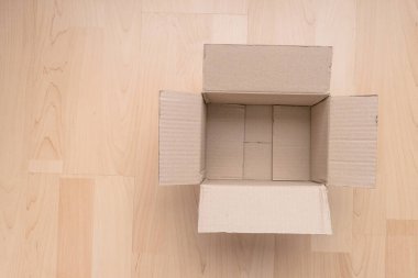 Ahşap arka planda boş dikdörtgen karton kutu. Çevrimiçi nesne arkaplanı alınıyor. Paket nesnesi gönderiliyor.