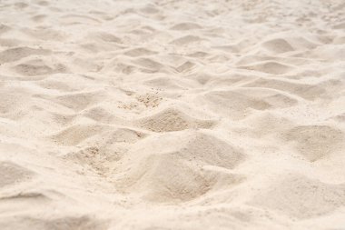 Sahilde kum, arka plan için. Arka plan olarak kahverengi kumsal dokusu. Yakın plan..