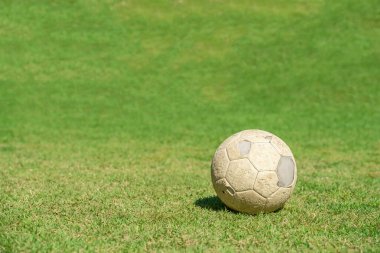 Futbol sahasının yeşil çimlerinde eski bir futbol topu. Klasik futbol.