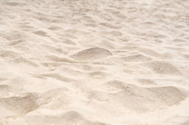 Sahilde kum, arka plan için. Arka plan olarak kahverengi kumsal dokusu. Yakın plan..