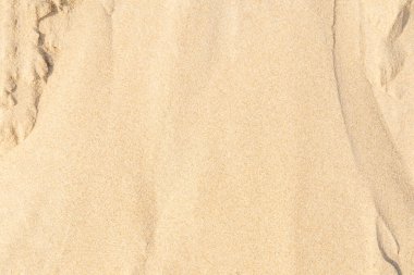 Sahilde kum, arka plan olarak. Açık bej rengi deniz kumu deseni, kumlu plaj dokusu arka planı..