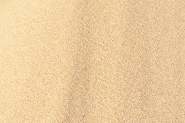 Sahilde kum, arka plan olarak. Açık bej rengi deniz kumu deseni, kumlu plaj dokusu arka planı..