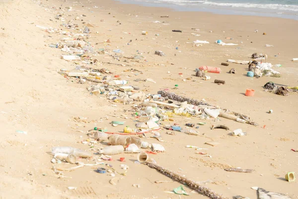 Trash on tropical Beach. Plastic pollution environmental problem. Plastic bottles and other garbage washed up on beach.