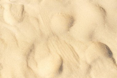 Sahildeki kum dokusu. Açık bej rengi deniz kumu deseni, kumlu plaj arkaplanı..
