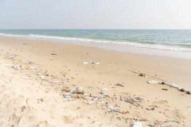Tropik plajda çöp. Plastik kirliliği çevre sorunu. Plastik şişeler ve diğer çöpler sahile vurmuş..