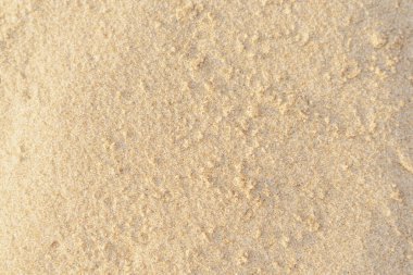 Sahildeki kum dokusu. Açık bej rengi deniz kumu deseni, kumlu plaj arkaplanı..